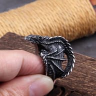 Close-up of a detailed black stainless steel dragon ring on a finger, showing its scales and head
