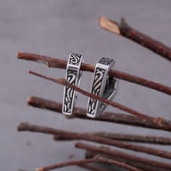 Close-up of the carved triangular patterns on the surface of the steel hoop earrings