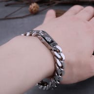 Side profile view of solid Cuban chain link bracelet in silver tone