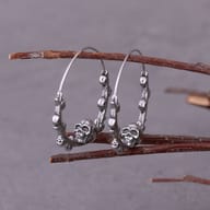 Close-up of sculpted skull center and branch texture on stainless steel hoop