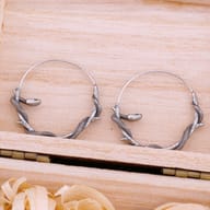 Close-up detail of the serpent head and textured scales on the stainless steel hoop earring