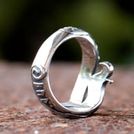 The Viking rune ring displayed with a subtle shadow, capturing its robust build and intricate symbolic patterns.
