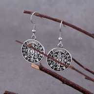 Angled view of a 316L stainless steel Saint Benedict Medal earring, showcasing its metallic luster and intricate design.