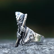 Antiqued stainless steel ring depicting a hooded gothic grim reaper with skeleton hands clutching a staff, set on a textured dark background.