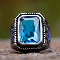 Men's gothic black stone signet ring resting on a textured surface highlighting its durable construction