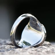 Side view of the Viking Tree of Life ring, highlighting the blue epoxy and yellow zircon on a textured surface.