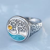 Angled view of the Viking Tree of Life ring, showcasing its textured background and overall design on rock.