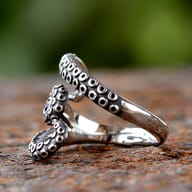 Stainless steel octopus wrap ring displayed on a rustic background