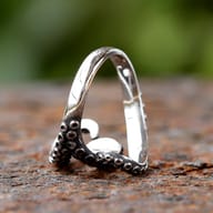 Angled view of octopus tentacle ring showcasing vibrant blue zircon