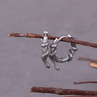 Close-up of the detailed coiled serpent scales on the steel hoop earring