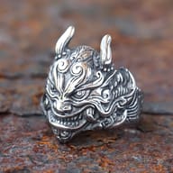 Close-up of the Oni mask ring's mouth and chin details on a textured surface.