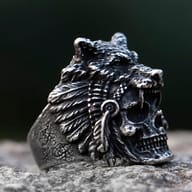 Angled close-up of the stainless steel skull wolf head ring, emphasizing the texture and depth of the design on a natural surface.