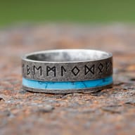 Close-up of engraved Elder Futhark runes and turquoise inlay on stainless steel band
