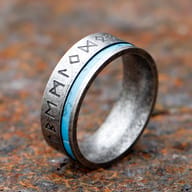 Men's 316L stainless steel Viking rune ring with turquoise inlay on a rustic metal surface