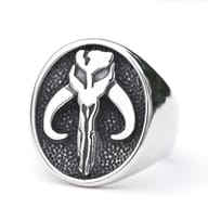 Side profile of the durable stainless steel Mandalorian ring, resting on an aged metal surface.