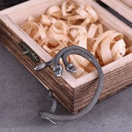 Close-up detail of the carved snake heads and scaled body of the three-headed serpent earring