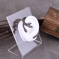Angled shot of the three-headed serpent ear wrap showing its curved contour and antique finish