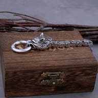 Two-tone Norse wolf bracelet displayed flat next to the wooden presentation box