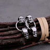Close-up of gothic double skull drop stud earring showing detailed skull carving