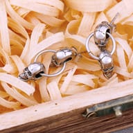 Stainless steel double skull drop earrings worn on an earlobe displaying punk style