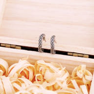 Side profile showing the curved tentacle shape and secure clasp of the earring