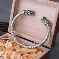 Viking dragon head twisted stainless steel torc cuff bracelet resting on a wooden gift box
