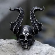 Angled perspective showing the detailed jaw and high curved horns of the skull ring