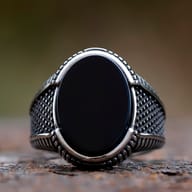 Close-up of the polished black zircon stone on a vintage men's ring
