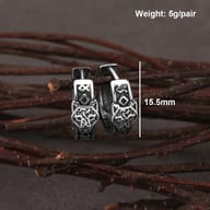 Both stainless steel Viking wolf earrings laid flat showcasing the dark oxidized finish