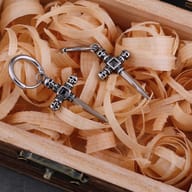 Front view of stainless steel skull cross drop earrings with secure huggie hoop clasps
