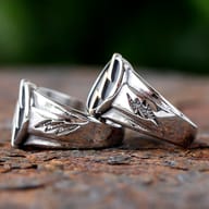 Close-up partial view of a stainless steel lightning bolt ring, showing the upper design elements.