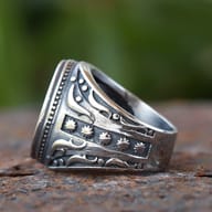 Detail view of the black inlay stone on the carved men's steel ring.