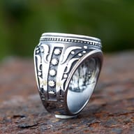 Angled shot showcasing the robust design and detailed carving of the men's ring.