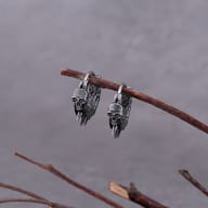 Close-up of detailed skull carving and outer spikes on stainless steel hoop earring