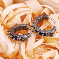 Men's gothic spiked skull hoop earring worn in earlobe showing scale and fit