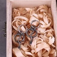 Close-up detail of the textured scales and serpent head on the steel snake drop earring