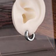 Detailed shot of ancient Nordic runes and Valknut symbol on silver-tone earrings