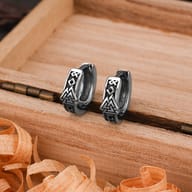 Close-up of Norse Valknut and rune engravings on stainless steel huggie earrings