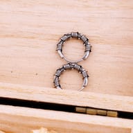 Model wearing the small gothic barbed wire hoop earring on earlobe