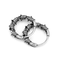 Macro view highlighting the darkened metallic texture and coiled wire details of the hoop earrings