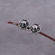 Angled perspective of vintage biker skull cross earrings in stainless steel