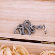 Top-down view of gothic coiled snake dangle earrings with hoop closures