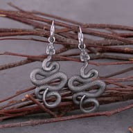 Close-up detail of textured 316L stainless steel coiled serpent drop earring