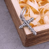 Stainless steel skull cross drop earrings laid flat together on a wooden surface