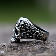 Frontal close-up of the detailed skull face, nose, and teeth on the stainless steel gothic punk ring.