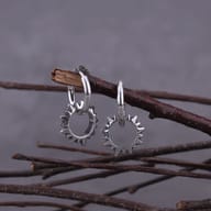 Pair of gothic stainless steel spiked circle hoop earrings suspended on a branch