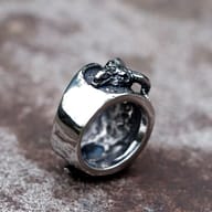 Side profile view of the intricate details and texture on the band of a gothic stainless steel ring.