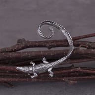Close up detail of the textured crocodile head and claw design on steel earring