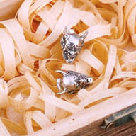 Stainless steel devil skull stud earrings set flat against a neutral surface