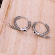 Close-up view of the detailed snake head and scale texture on the stainless steel hoop earring